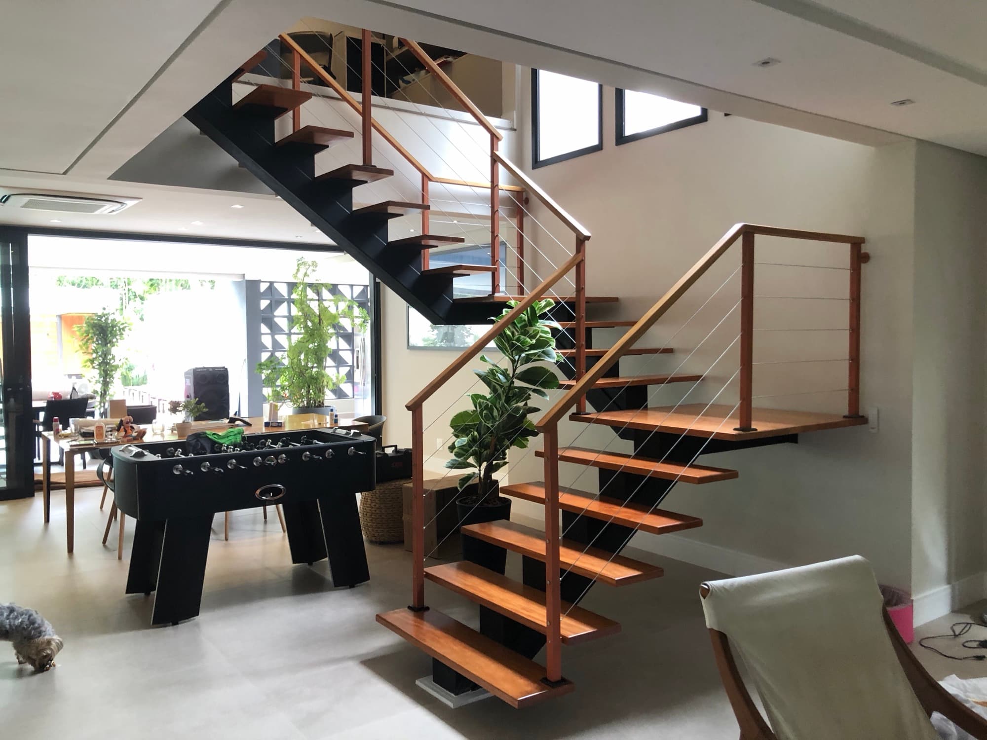 Escada com design industrial e degraus de madeira em uma sala de jogos moderna